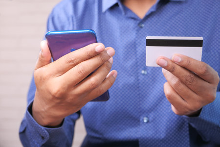 online payment with credit card. holding credit card and using smart phone