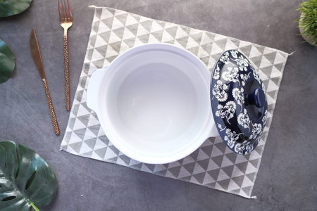 cutlery and empty bowl on black background top down