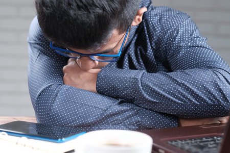Depressed man feeling sick and worried about financial problemの写真素材