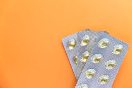 Close up of many vitamin capsule on orange backgroundの写真素材