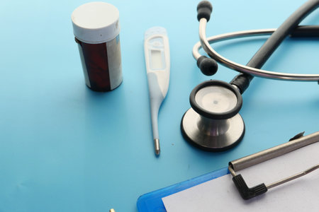 stethoscope and pills container on wooden background