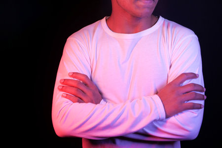 unrecognized man with casual dress arm crossed standing against white wall ,の写真素材