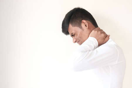 man suffering from neck pain at home.の写真素材