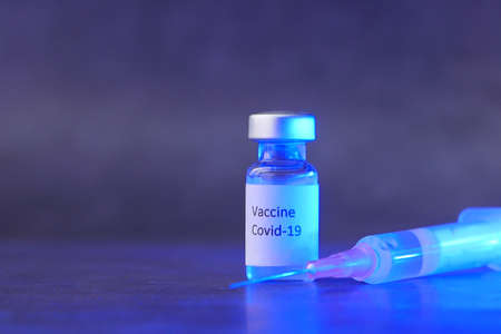 Close up of coronavirus vaccine and syringe on black backgroundの写真素材