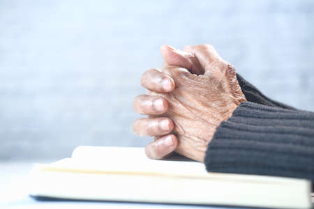Close up of senior women hand on a book prayingの写真素材
