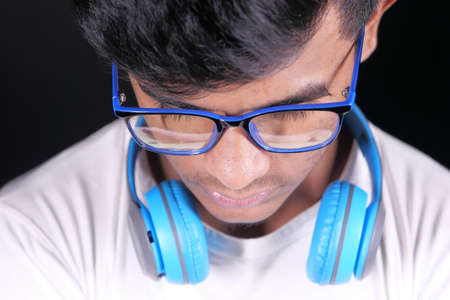 young man in gray t-shirt with head phone on black background .の写真素材