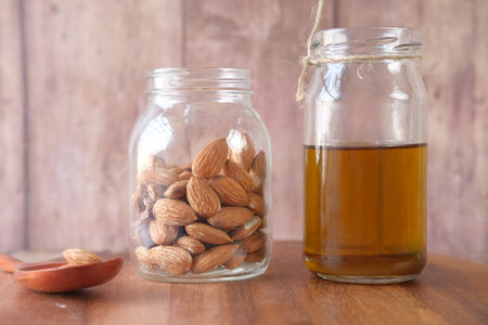 Almond oil in bottle on wooden background. top downの写真素材