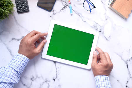 Flat composition of young man suing digital tablet on office deskの写真素材