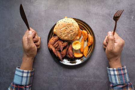 top view of man hand with knife waiting for eating junk foodの写真素材