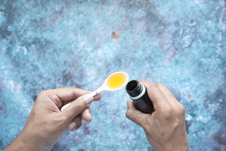 pour liquid medicine on top of spoonの写真素材