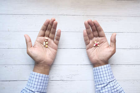 top view of many medical pills on palm of handの写真素材