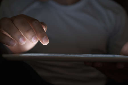 Close up of hacker hand stealing data from digital tabletの写真素材