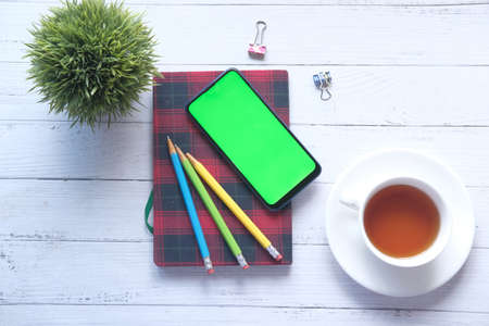 top view of smart phone and notepad on tableの写真素材