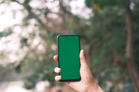 rear view of young man using smart phone at outdoorの写真素材