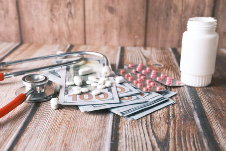 Healthcare cost concept with us dollar , container and pills on table