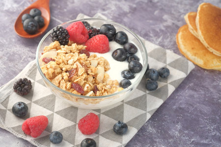 Granola with yogurt and berries in bowl on black backgroundの写真素材
