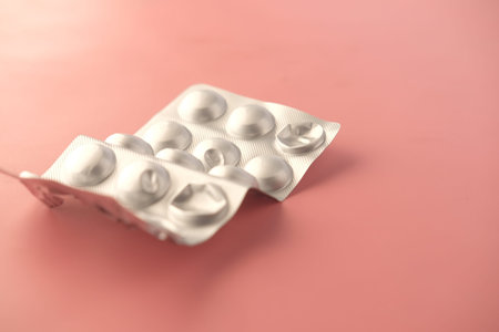 Close up of pills of blister pack on a pink background