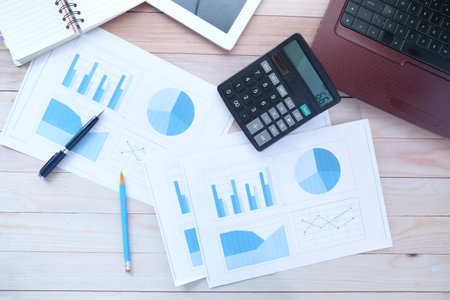 financial graph, calculator and notepad on table