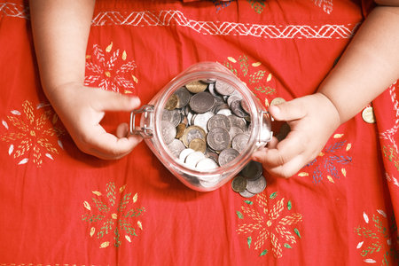child girl pile coin for saving on bed , top view
