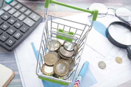 close up of coins in a shopping card on table