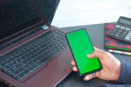 top view of man hand using smart phone on office desk
