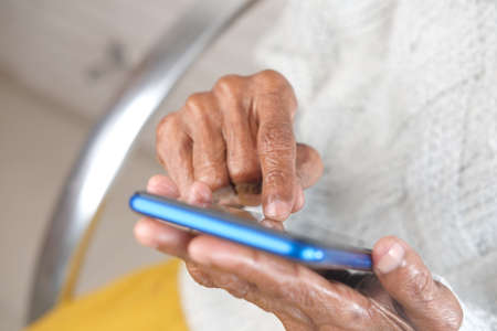 senior women hand using smart phone close upの写真素材