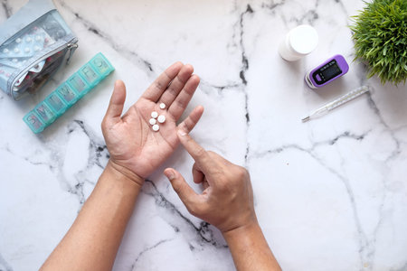 top view of man hand holding pills on table