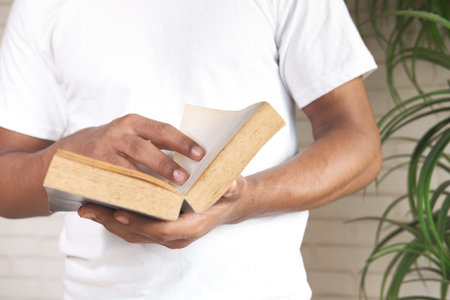 close up of young man hand reading a book