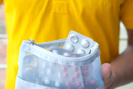 Close up of hand holding blister packs .の写真素材