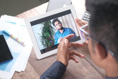 businessman holding digital tablet discussing ideas in video conference