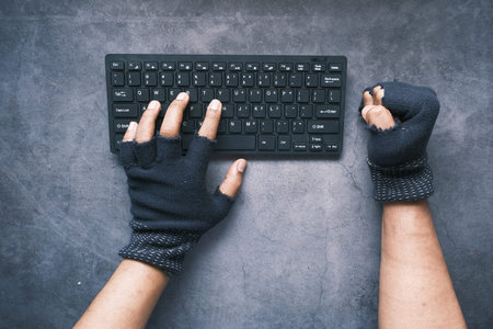 hacker hand stealing data from laptop top down