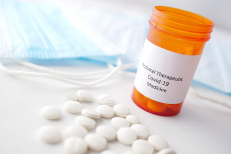 covid 19 medical pills and blue surgical masks on table