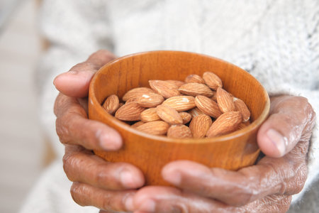 close up senior women hand holding a bowl on almond