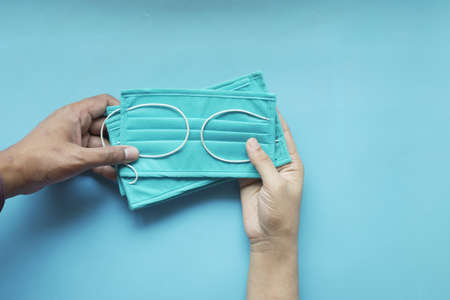 hand holding surgical face mask, top viewの写真素材