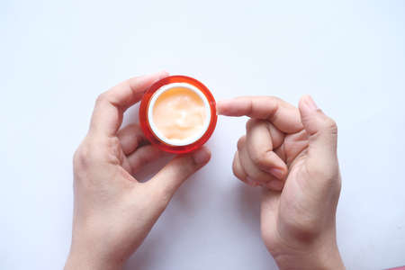 woman applying beauty cream onto skin at home top viewの写真素材