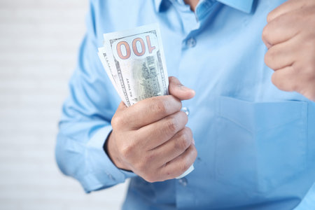 Close up of man hand counting 100 us dollar cashの写真素材