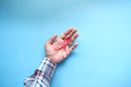 hand holding red HIV ribbon top downの写真素材