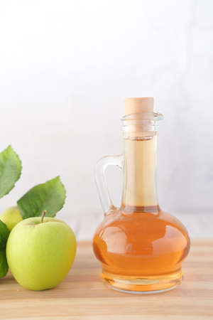 apple vinegar in glass bottle with fresh green apple on tableの写真素材