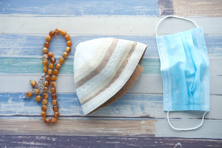 prayer rosary ,hat and mask on table