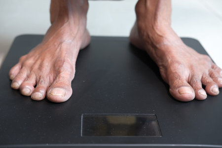 senior womens feet on weight scale close up.