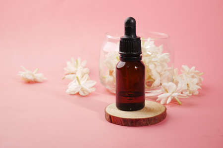 eucalyptus essential oils in a glass bottle and flower on pink backgroundの写真素材