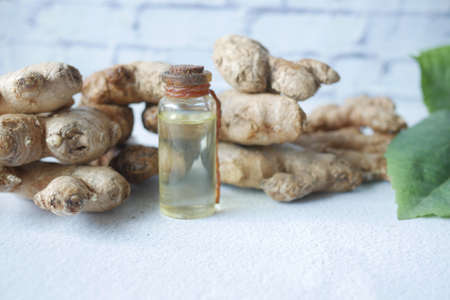 Close up of Gingers and oils in a small glass bottle on tableの写真素材