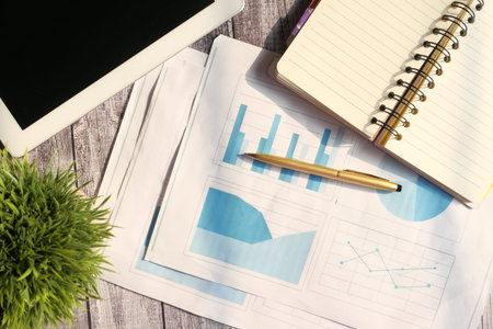 financial graph, calculator and notepad on table