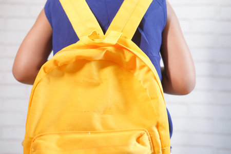 unrecognized child girl with school bag ready to go to school