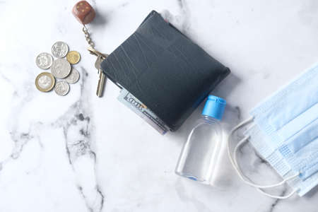 wallet, coins, hand sanitizer and mask on tableの写真素材