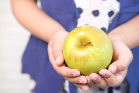 child girl green apple on white backgroundの写真素材