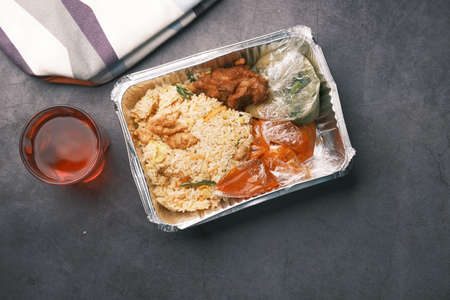 chicken biryani meal in a take away box on table.の写真素材