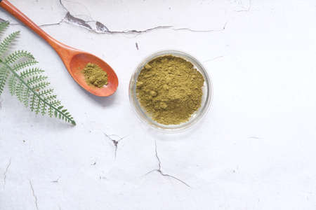 The wooden bowl with rehydrated henna on tableの写真素材