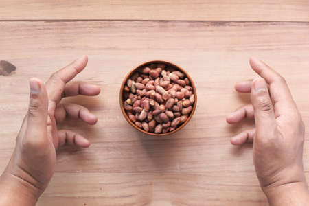 Processed pea nuts in a bowl on table top down .の写真素材