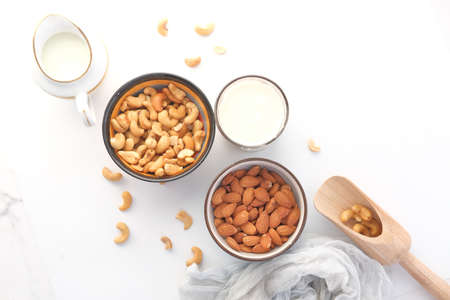 almond , cashew nut in glass bowl and milk on white backgroundの写真素材